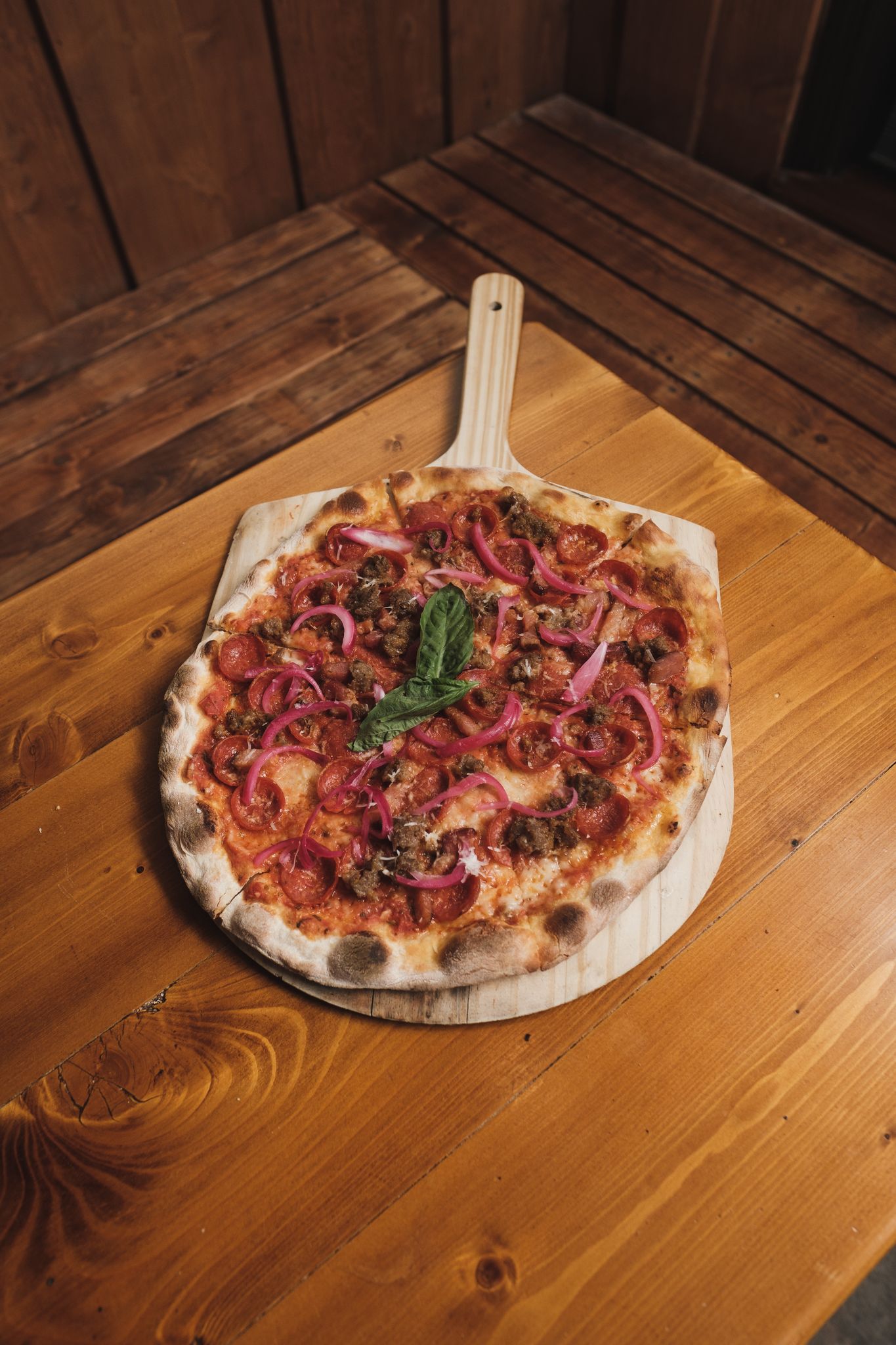 Delicious gourmet pizza with fresh toppings on a rustic wooden table.